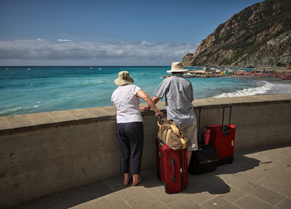 Photo by Vidar Nordli-Mathisen man and woman standing beside concrete seawall looking at beach