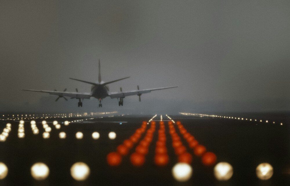 Photo by Amsterdam City Archives Airplane landing on a runway at dusk